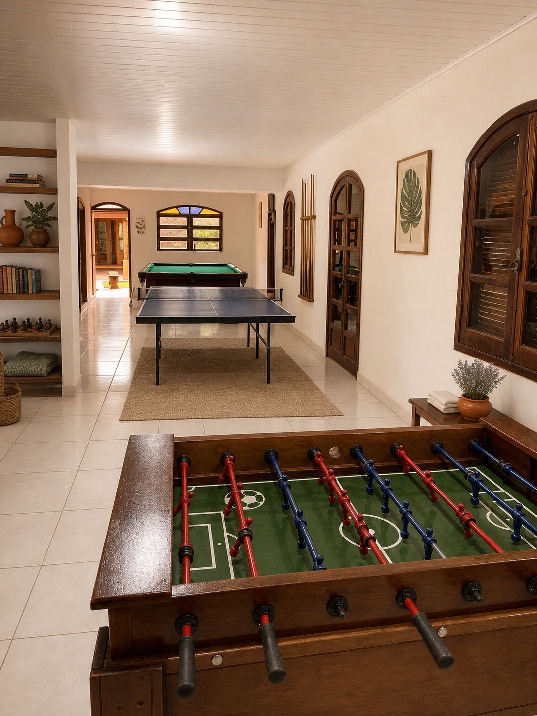 Sala de jogos com mesa de sinuca, pebolim e ping-pong