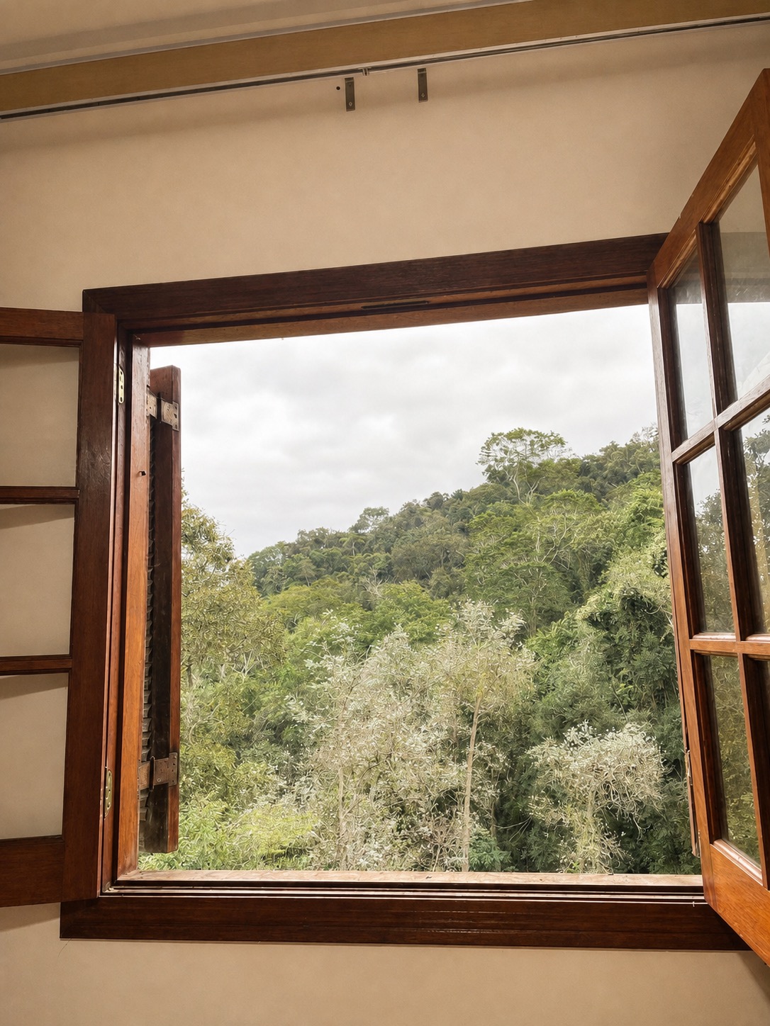 Janela de madeira da Suíte 1 aberta para a vista da Mata Atlântica