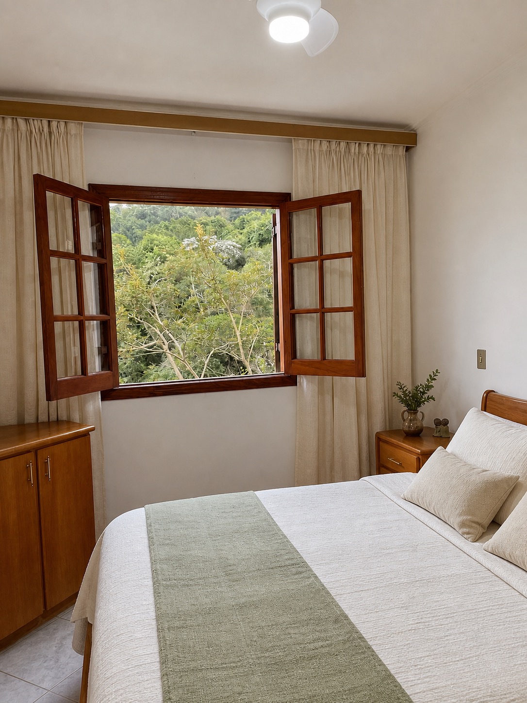 Cama de casal da Suíte 2 voltada para janela de madeira aberta para a mata