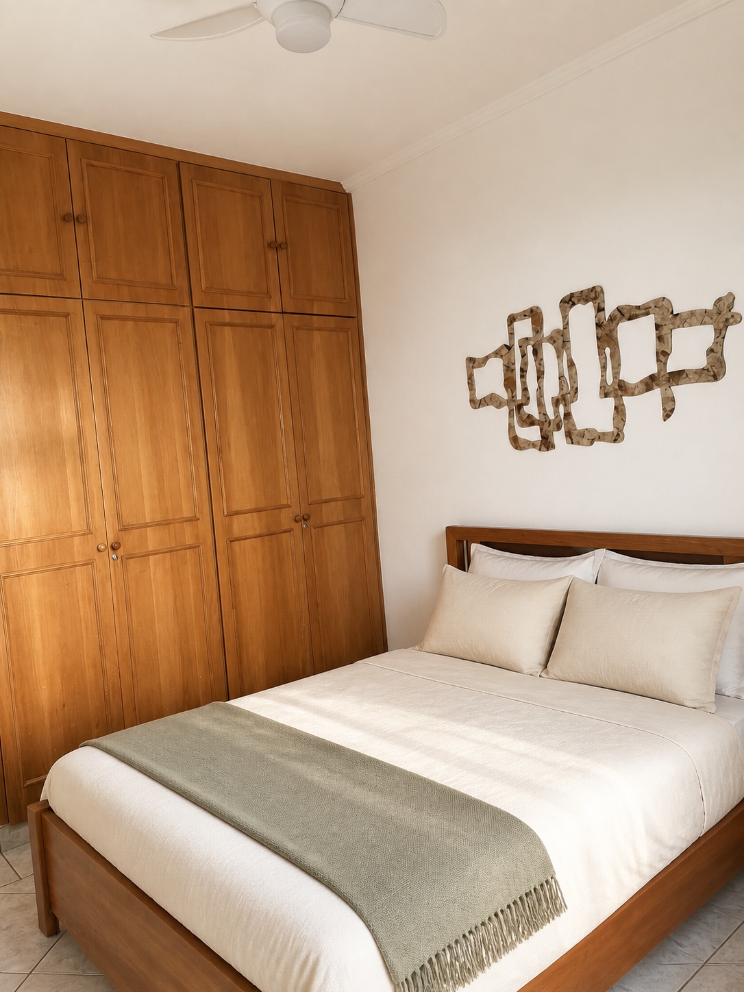 Cama de casal da Suíte 3 com cabeceira de madeira e armário embutido ao lado